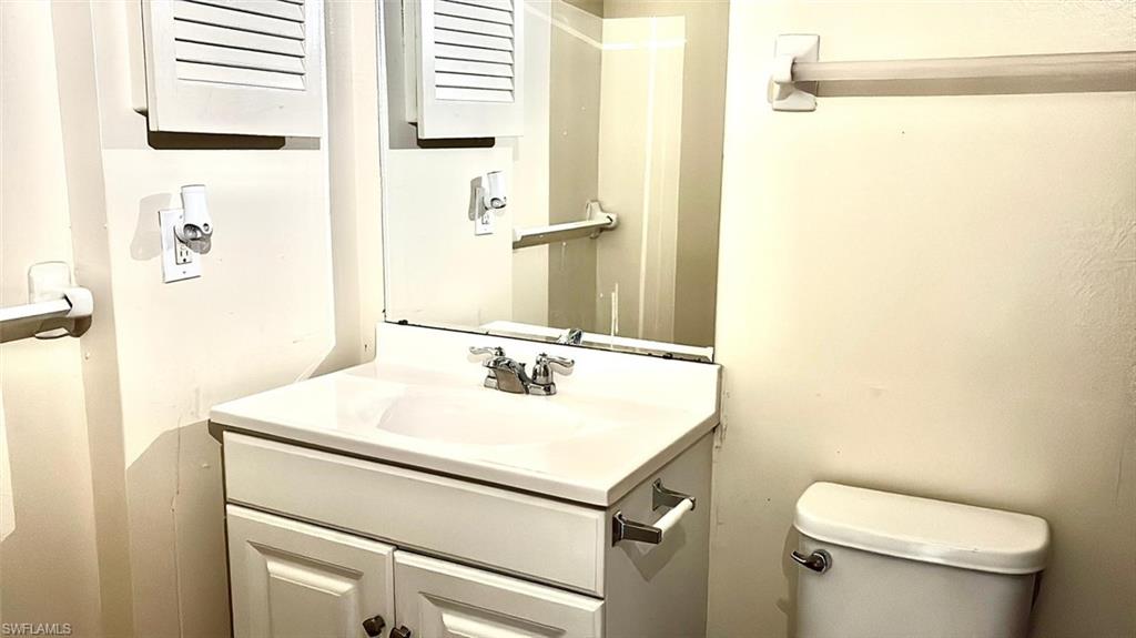 Half bathroom featuring vanity and toilet