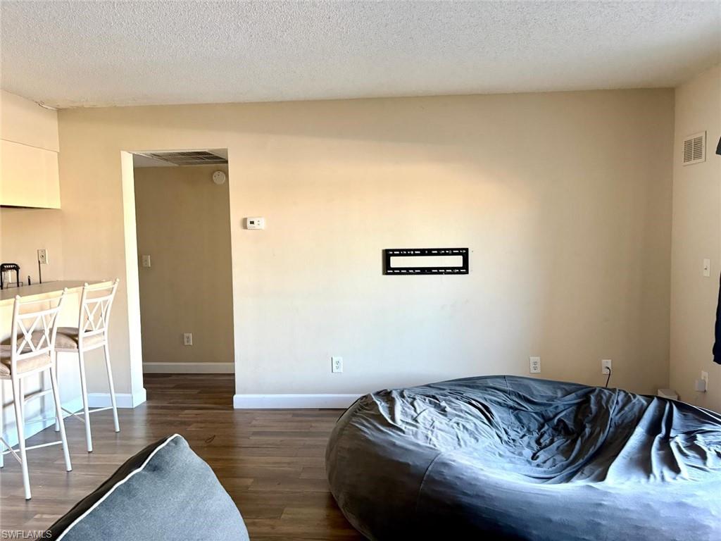 Bedroom featuring a textured ceiling and wood finished floors