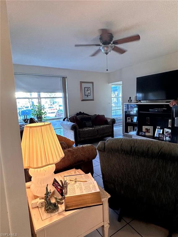 Living area featuring tile patterned flooring and ceiling fan