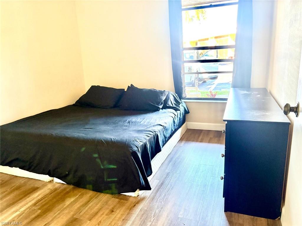 Bedroom with wood finished floors and baseboards