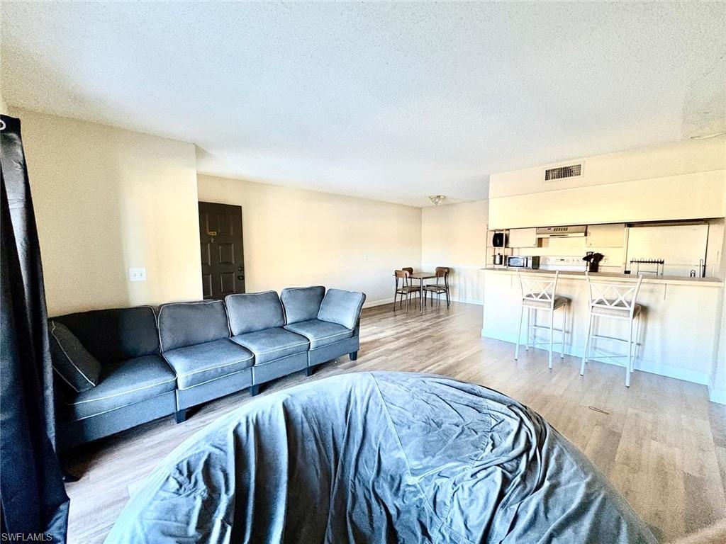 Living room featuring light wood finished floors and a textured ceiling