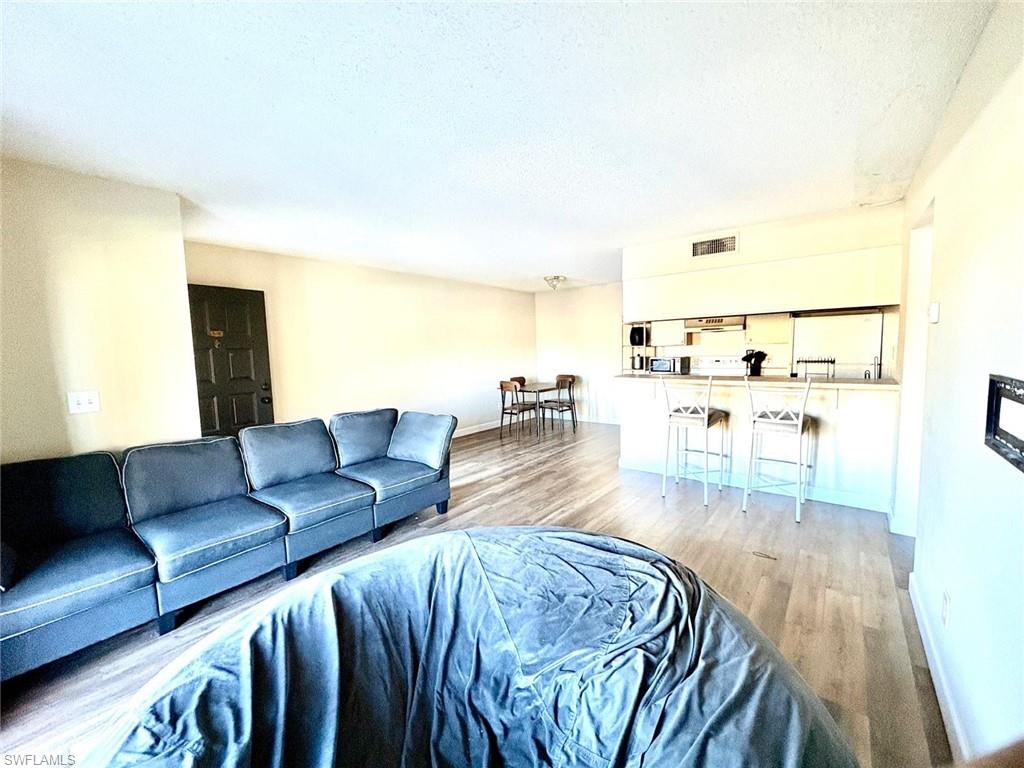 Living room with light wood-style flooring and a textured ceiling