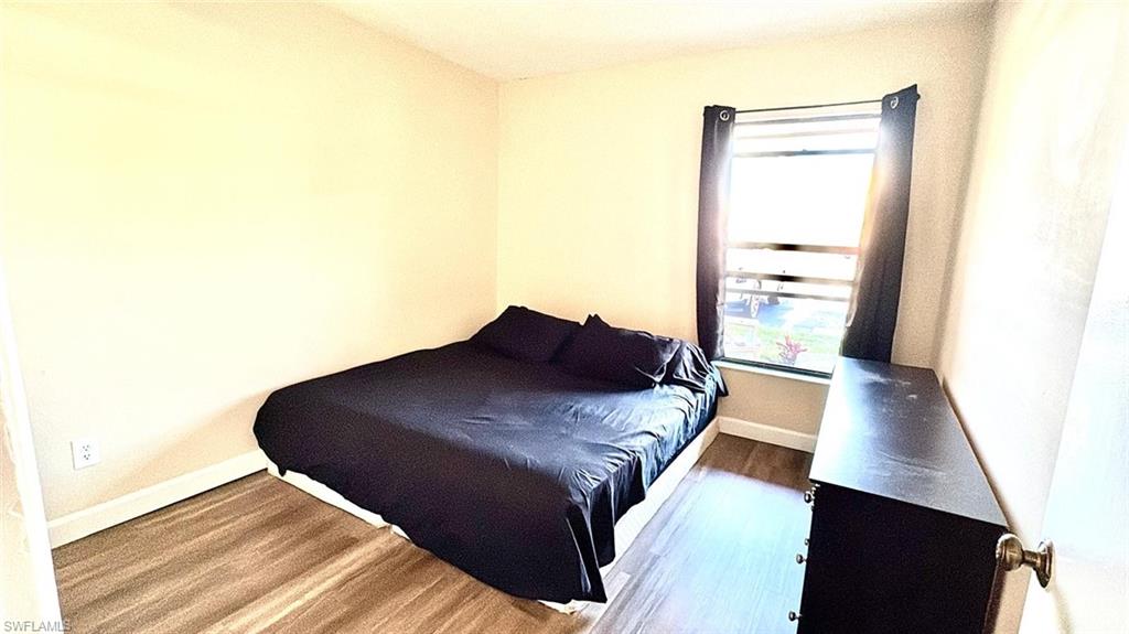 Bedroom featuring wood finished floors and baseboards