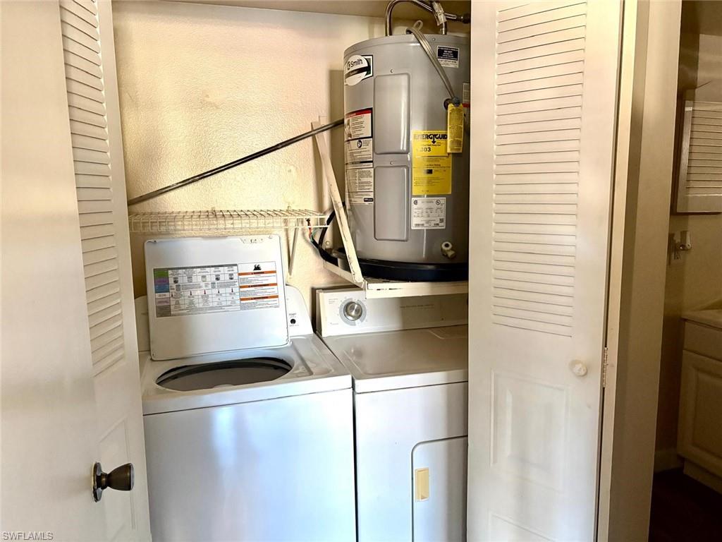 Laundry area featuring electric water heater and washer and clothes dryer
