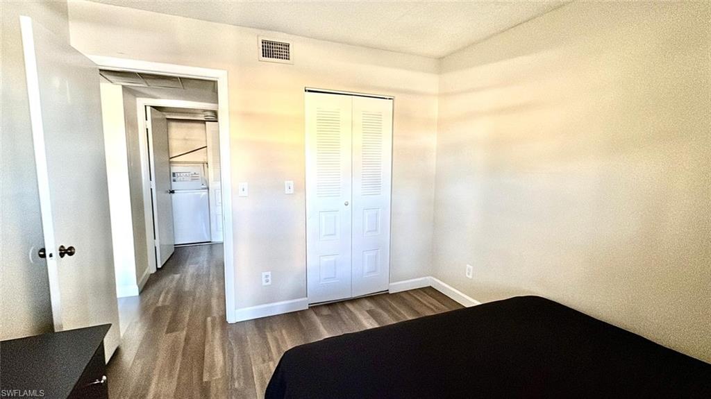 Unfurnished bedroom with dark wood finished floors and a closet