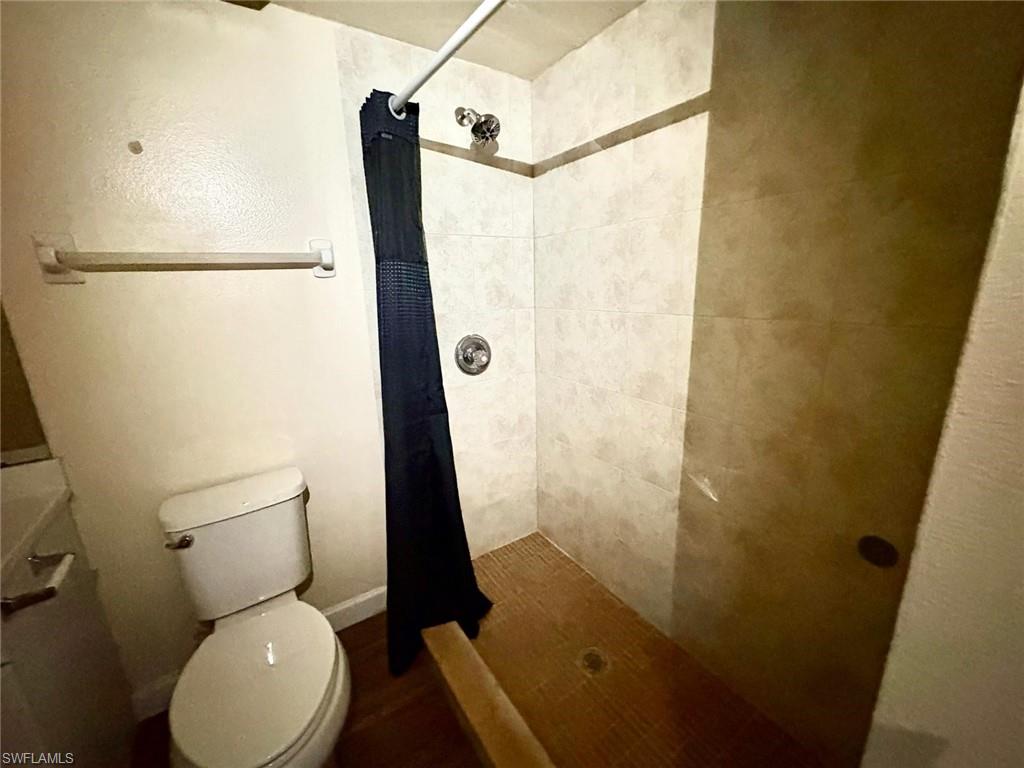 Full bath featuring a shower stall and toilet