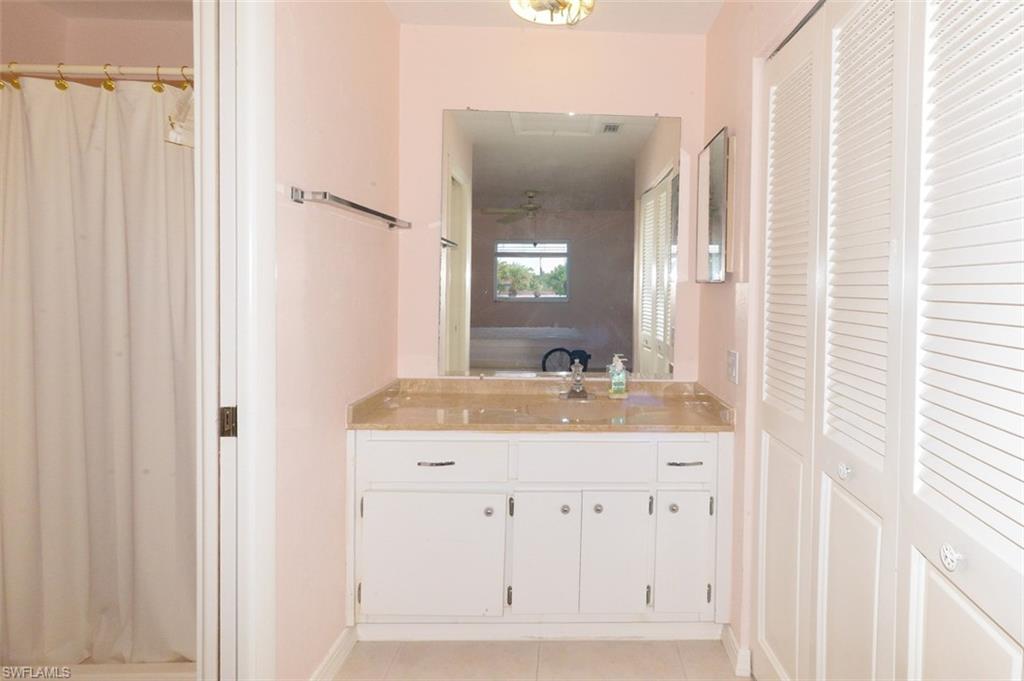 Primary bedroom suite bathroom with door to shower and commode on left and closet on right.