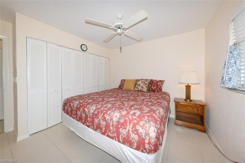 Guest bedroom with large tile flooring and spacious wall to wall closet.
