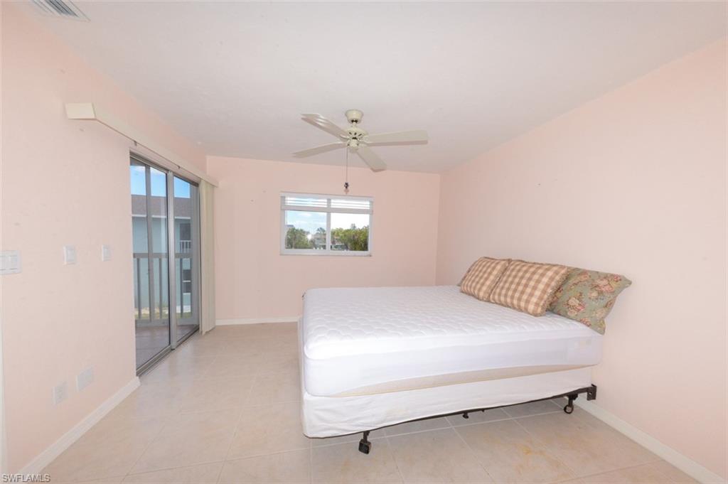 Primary bedroom suite with large tile flooring, updated window and sliding glass doors leading to lovely Lanai.