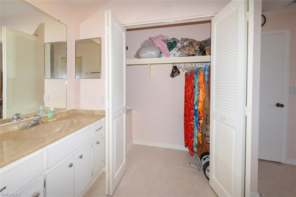 Primary bedroom suite bathroom with closet on right.
