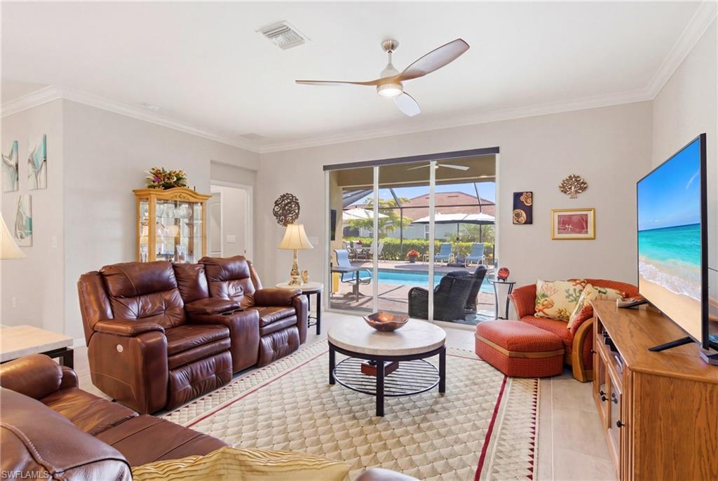 Spacious living room with direct access to the screened lanai, seamlessly connecting indoor living to the private pool area.