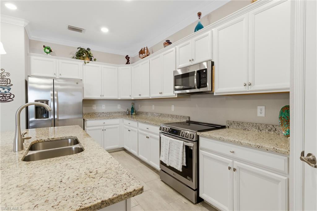 Upgraded kitchen featuring granite countertops, induction range, newer appliances, and a generous walk-in pantry.