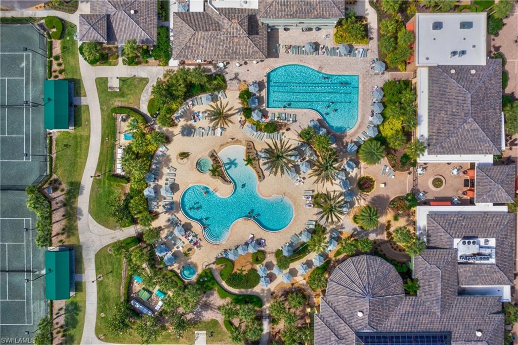 Top-down view of the resort-style pool area surrounded by palm trees and well-maintained amenities.
