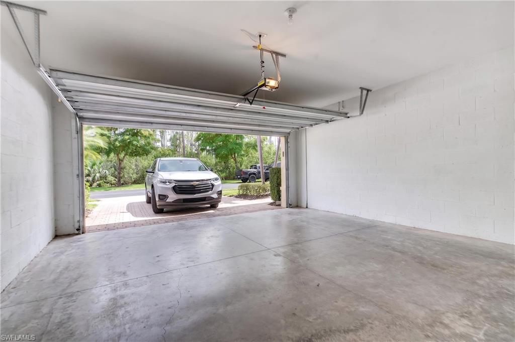 Spacious garage with concrete flooring and painted block walls