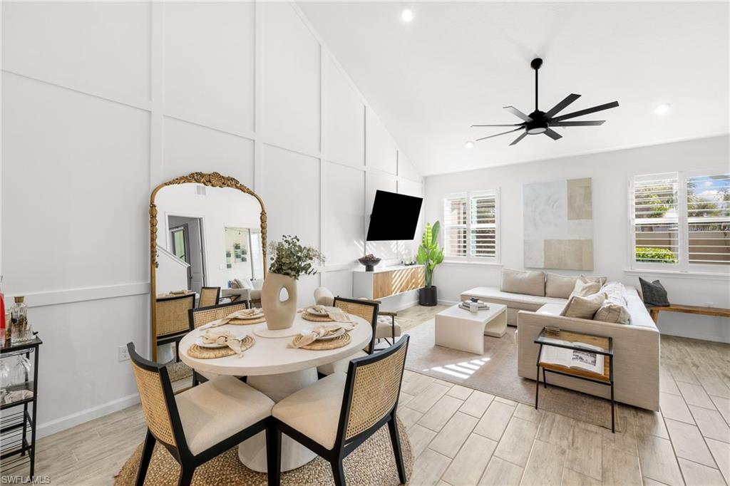 Open-concept living space with a vaulted ceiling, recessed lighting, and a modern ceiling fan