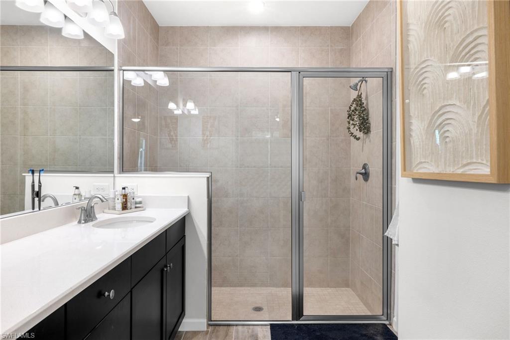 Shower with neutral-toned tile surround and glass enclosure