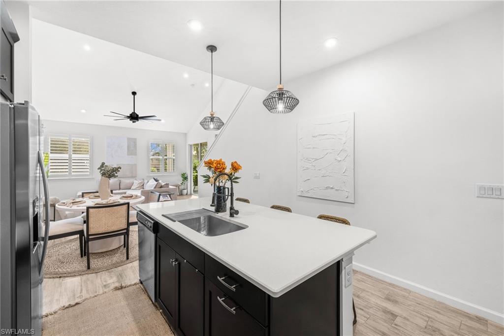 Kitchen island featuring a single-basin sink, black faucet, and white countertop