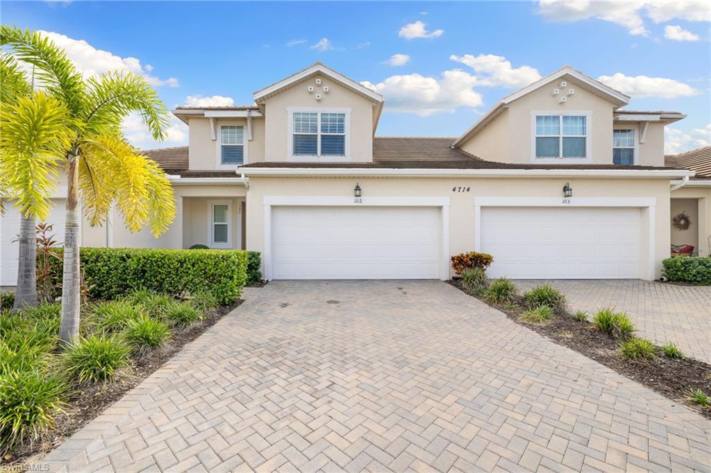 Two-story stucco exterior featuring a tiled roof and two attached garage doors