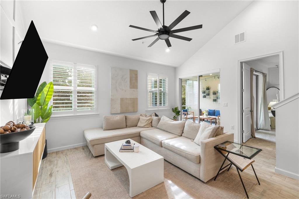 Bright living area featuring vaulted ceilings, recessed lighting, and a modern ceiling fan
