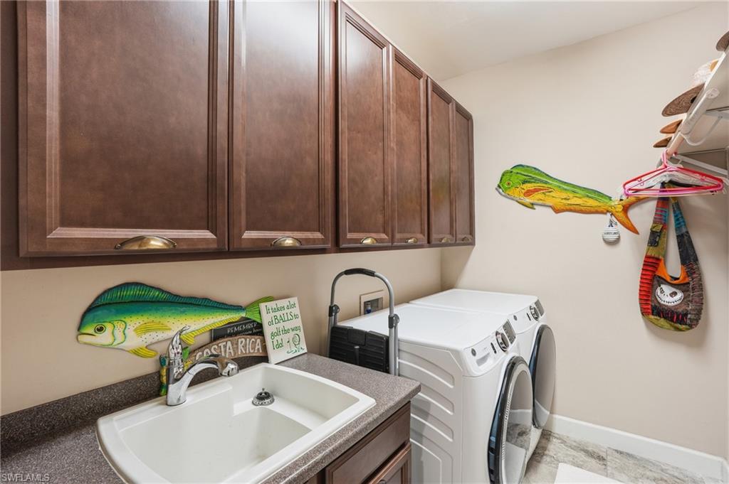 Dedicated laundry area featuring abundant cabinetry, a utility sink with a chrome faucet, and a spacious countertop