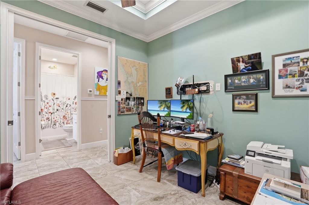 Versatile room featuring tile flooring, crown molding, and direct access to a full bathroom