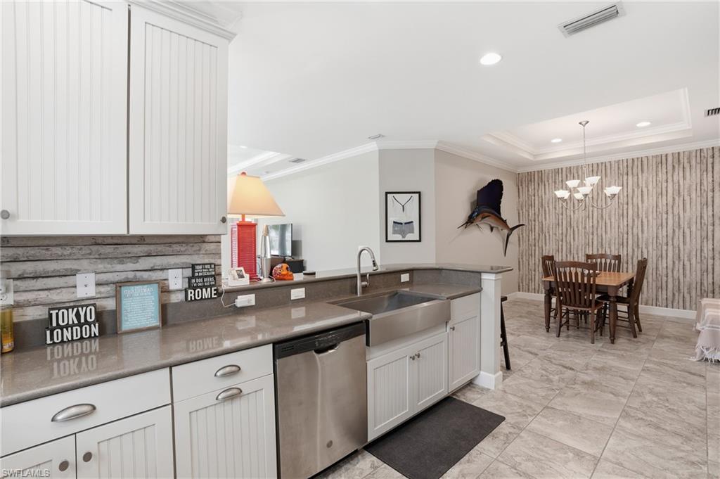 Kitchen featuring white beadboard cabinetry, stainless steel appliances, a farmhouse sink, and light-toned countertops