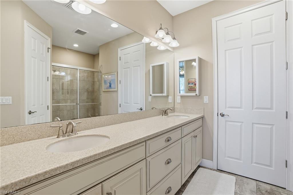 Double vanity featuring undermount sinks, brushed nickel fixtures, and a speckled countertop