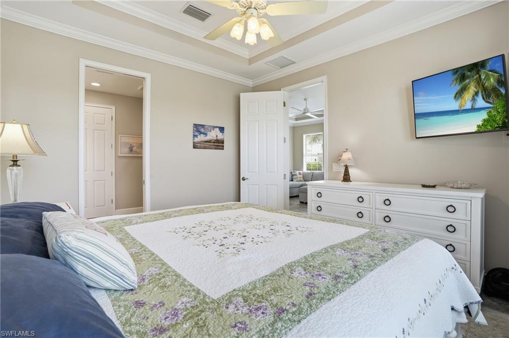 Neutral wall tones with crown molding and a tray ceiling