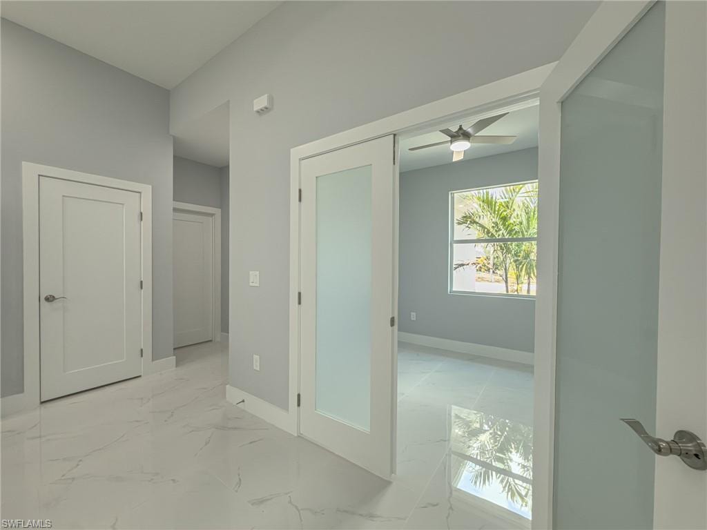 Hallway with marble finish floor and baseboards