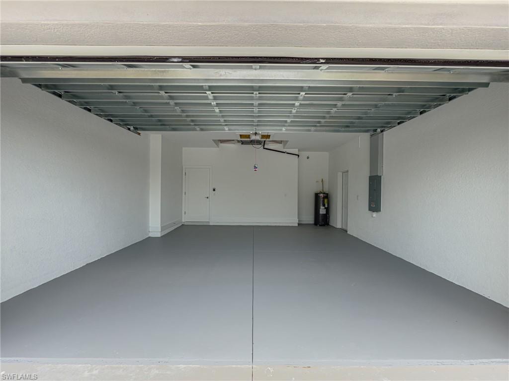 Garage featuring electric panel and water heater