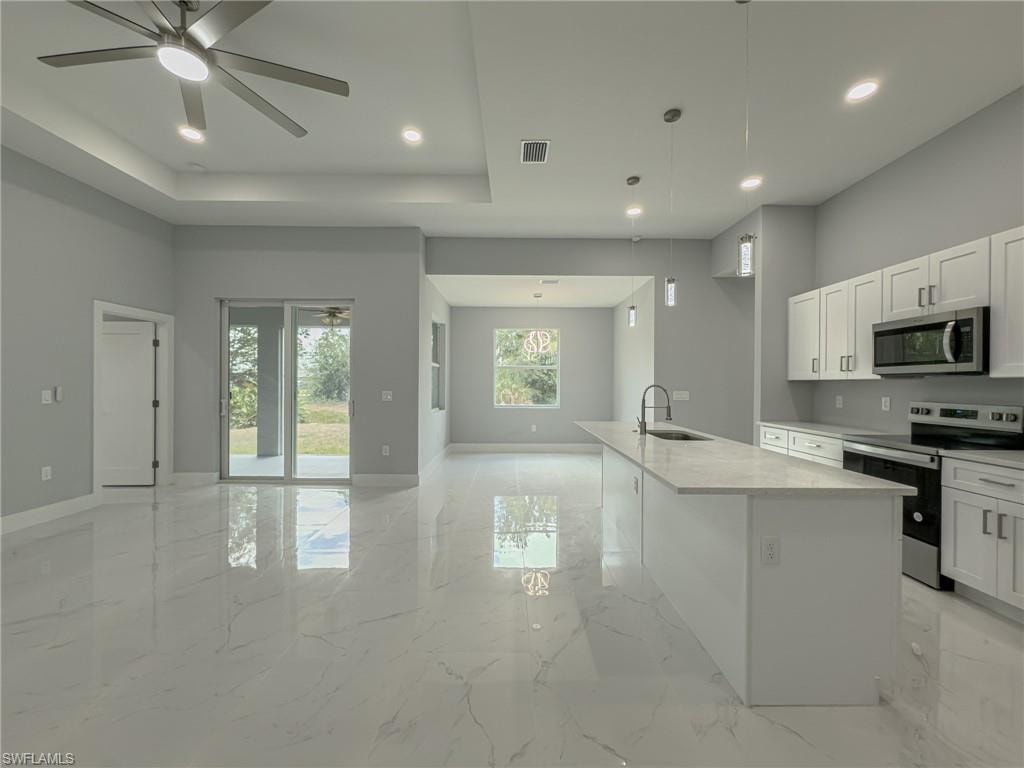 Kitchen featuring marble finish floor, visible vents, appliances with stainless steel finishes, and open floor plan