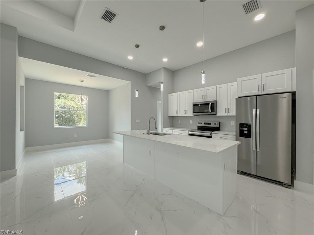 Kitchen featuring baseboards, visible vents, appliances with stainless steel finishes, and a sink