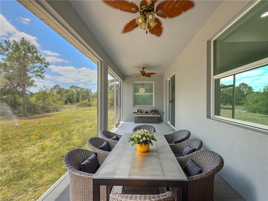 Sunroom featuring outdoor dining area and a ceiling fan
