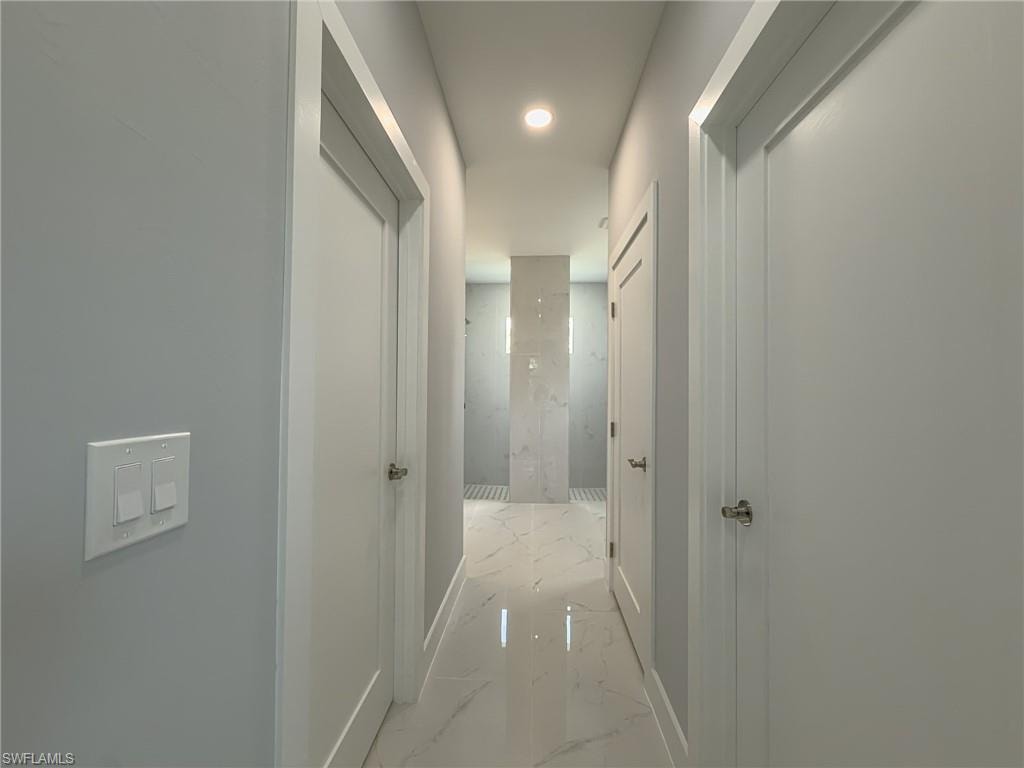Hall featuring recessed lighting, marble finish floor, and baseboards