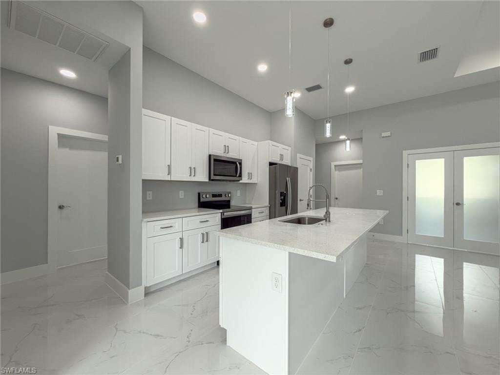 Kitchen with baseboards, visible vents, appliances with stainless steel finishes, and a sink