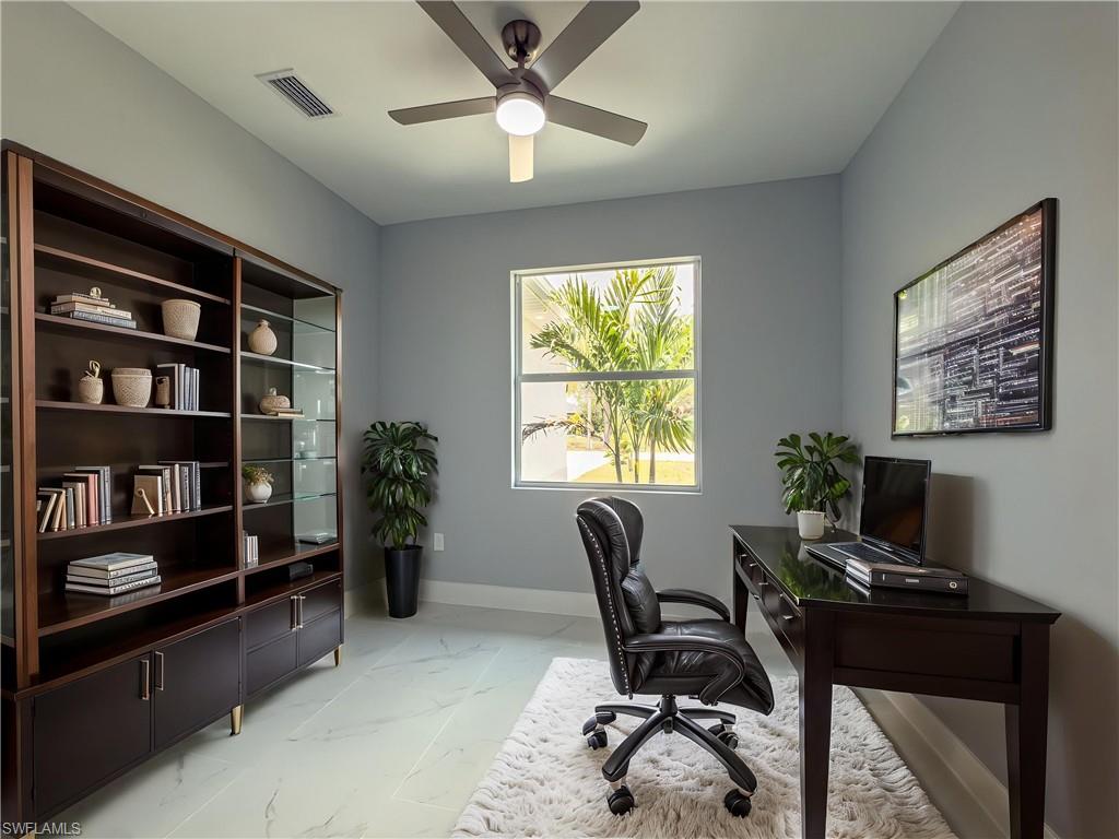 Office with ceiling fan, visible vents, baseboards, and marble finish floor