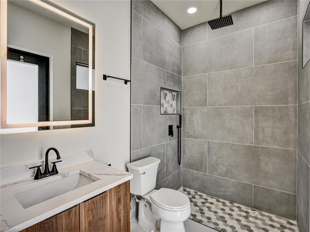 Modern bathroom featuring a wood-finish vanity with an integrated sink and white countertop