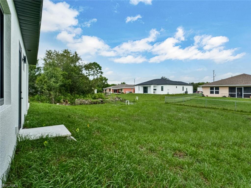 Expansive rear yard with green space and mature landscaping