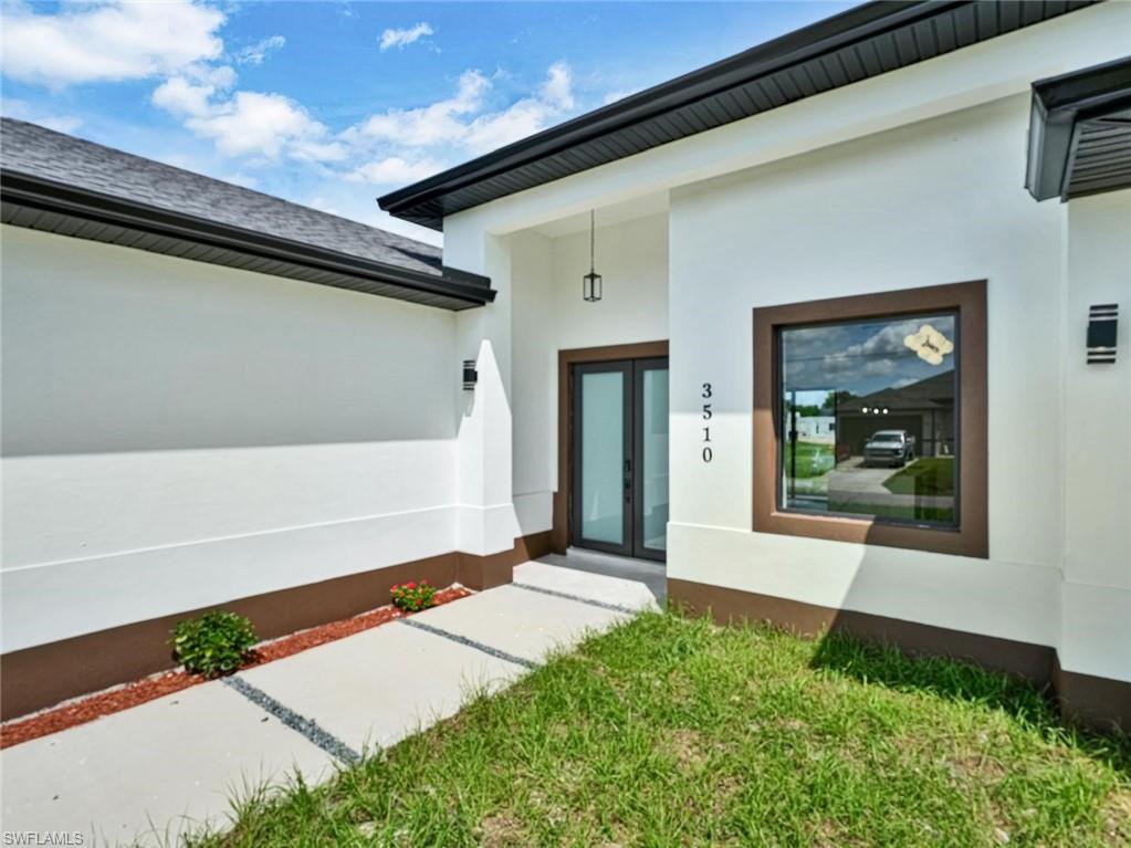 Contemporary exterior featuring white stucco walls and dark trim