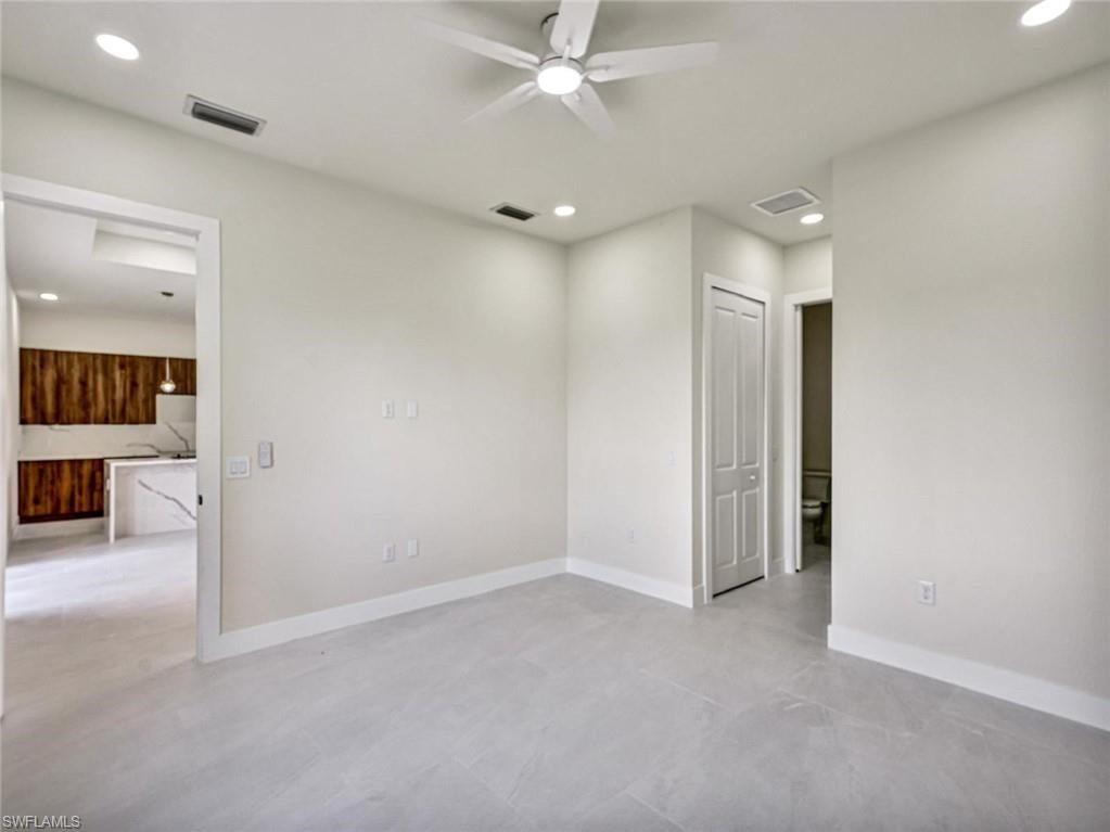 Spacious room featuring light-colored tile flooring, white baseboards, and neutral wall tones