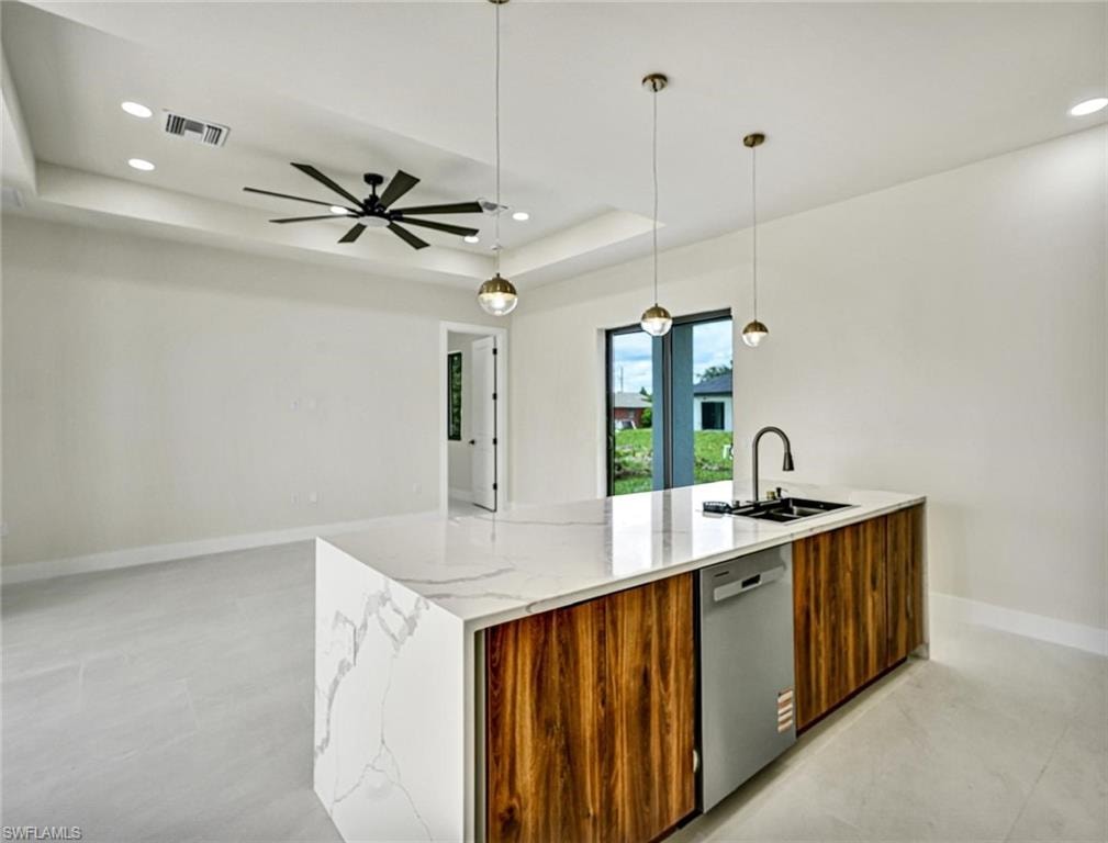 Kitchen island featuring a waterfall countertop with veining, a deep single-basin sink, and a matte black gooseneck faucet