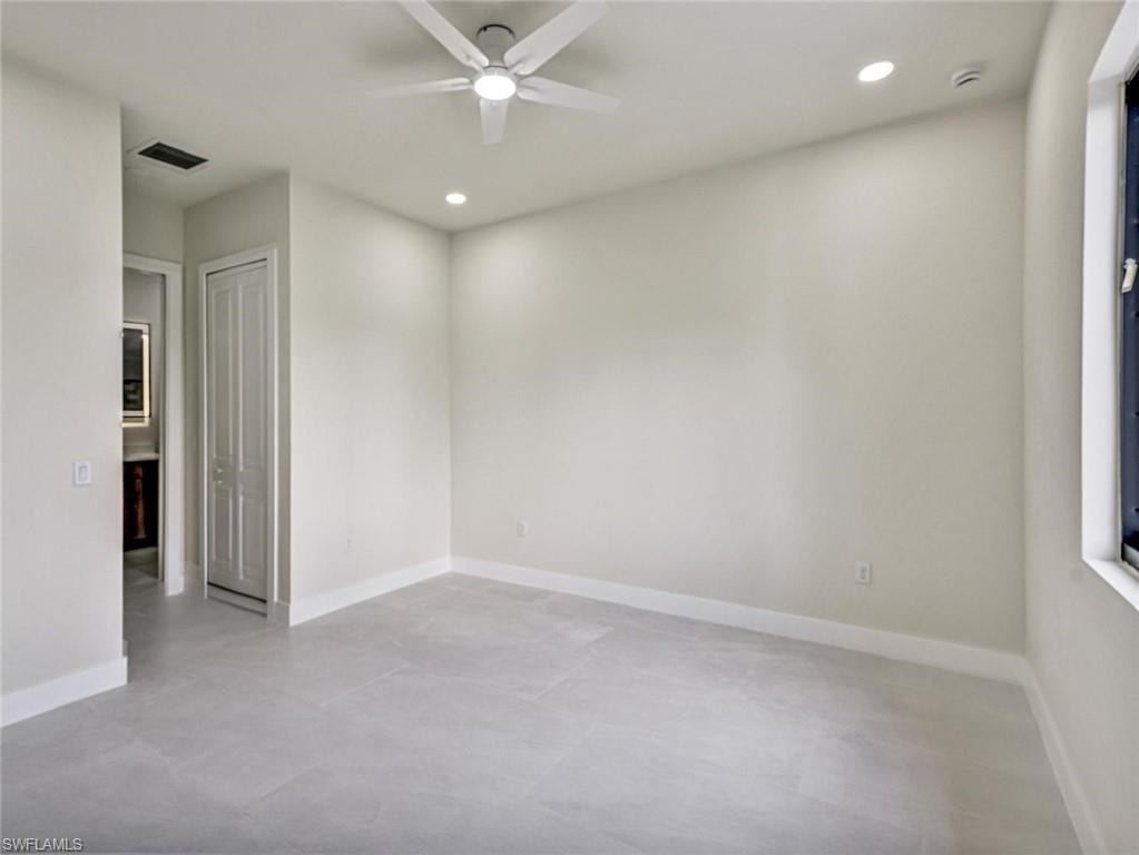 Neutral-toned room featuring a ceiling fan with integrated lighting, recessed lighting, and light gray tile flooring
