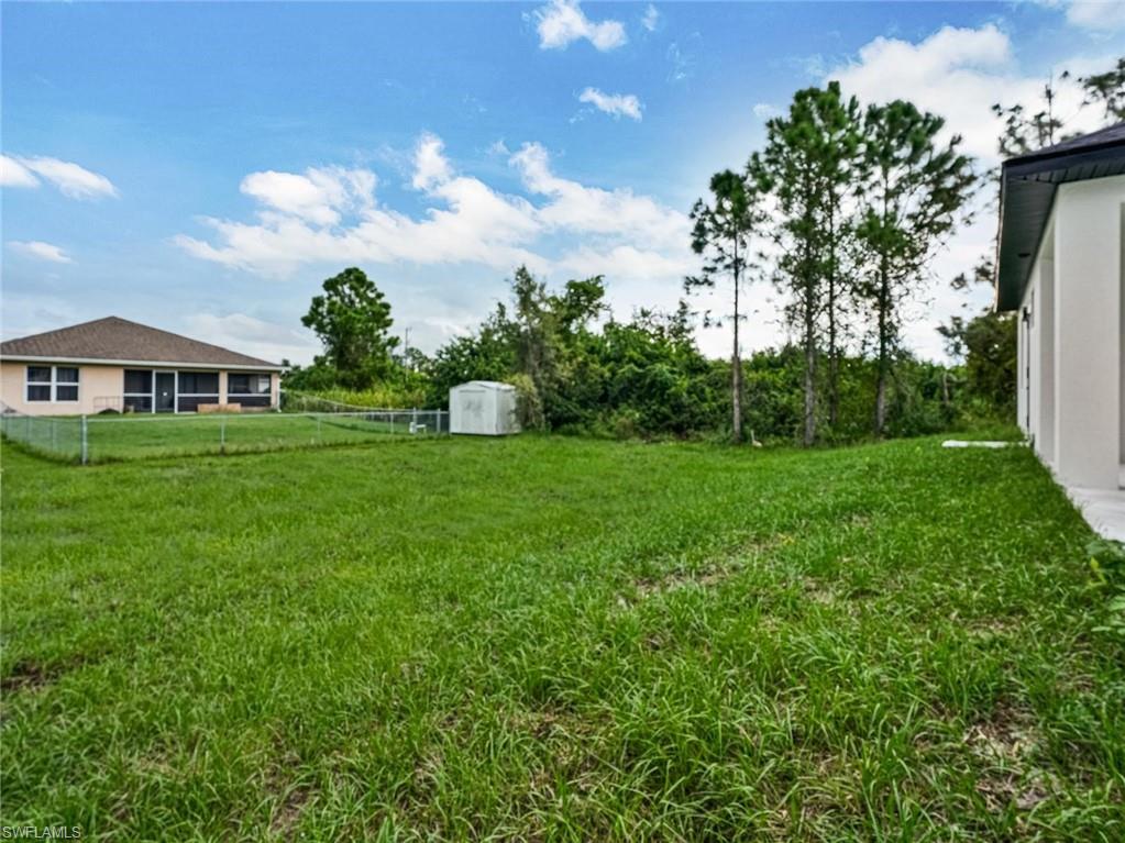 Expansive green yard space with natural vegetation bordering the property