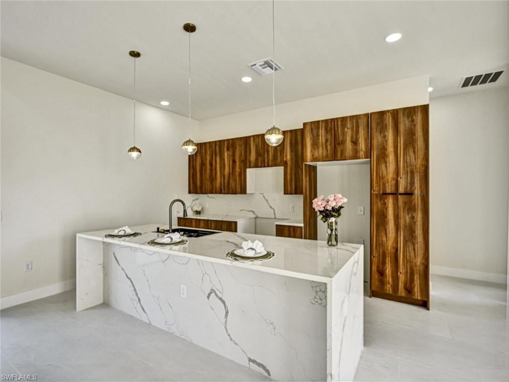 Waterfall island with integrated cooktop and black gooseneck faucet