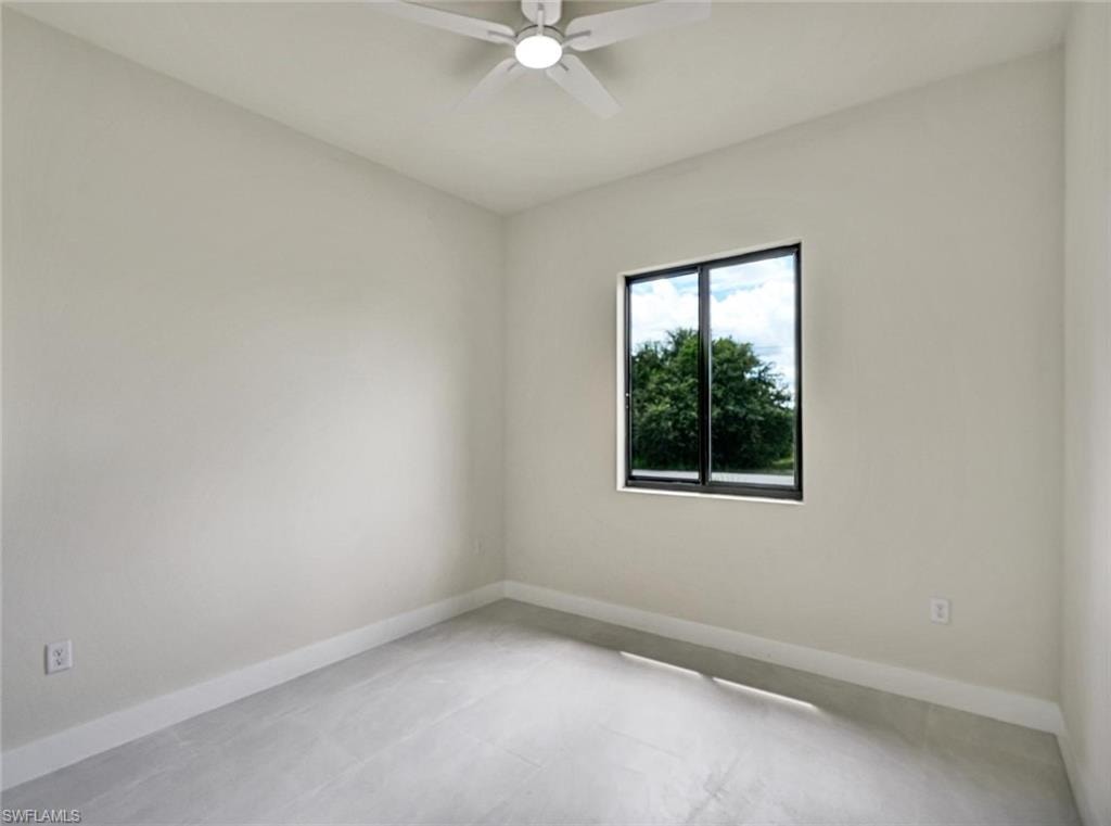 Room featuring light grey walls, a single window with a black frame, and a white ceiling fan with integrated lighting