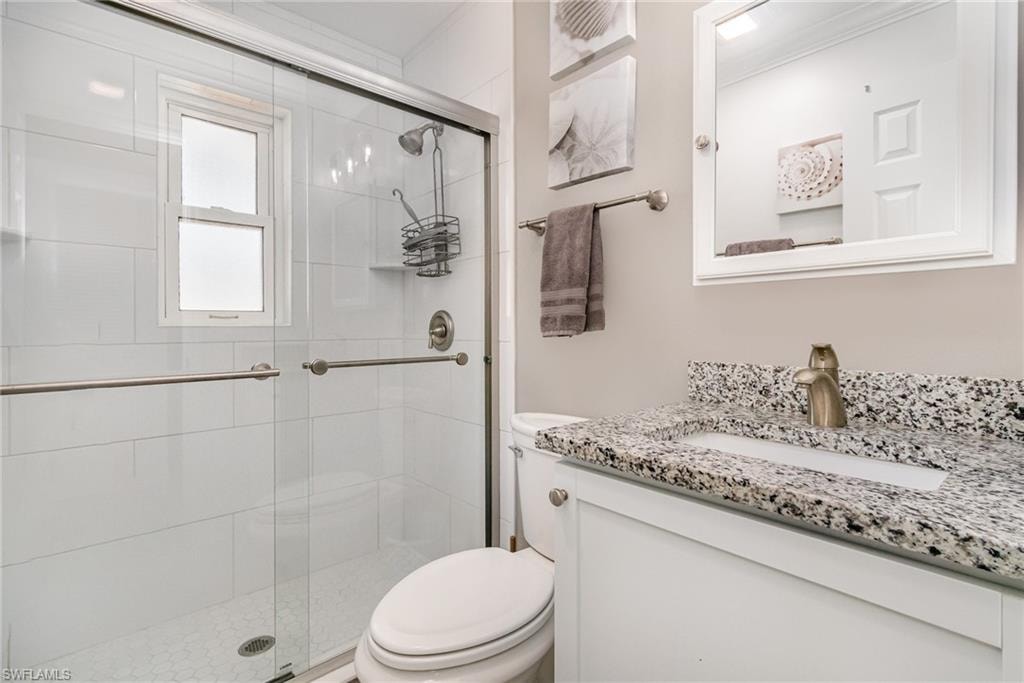 Baths have a glass-enclosed shower and white tile surround!