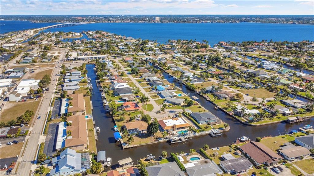 Great view of newer tan shingle roofs on both buildings and Cape Coral Bridge in the background.