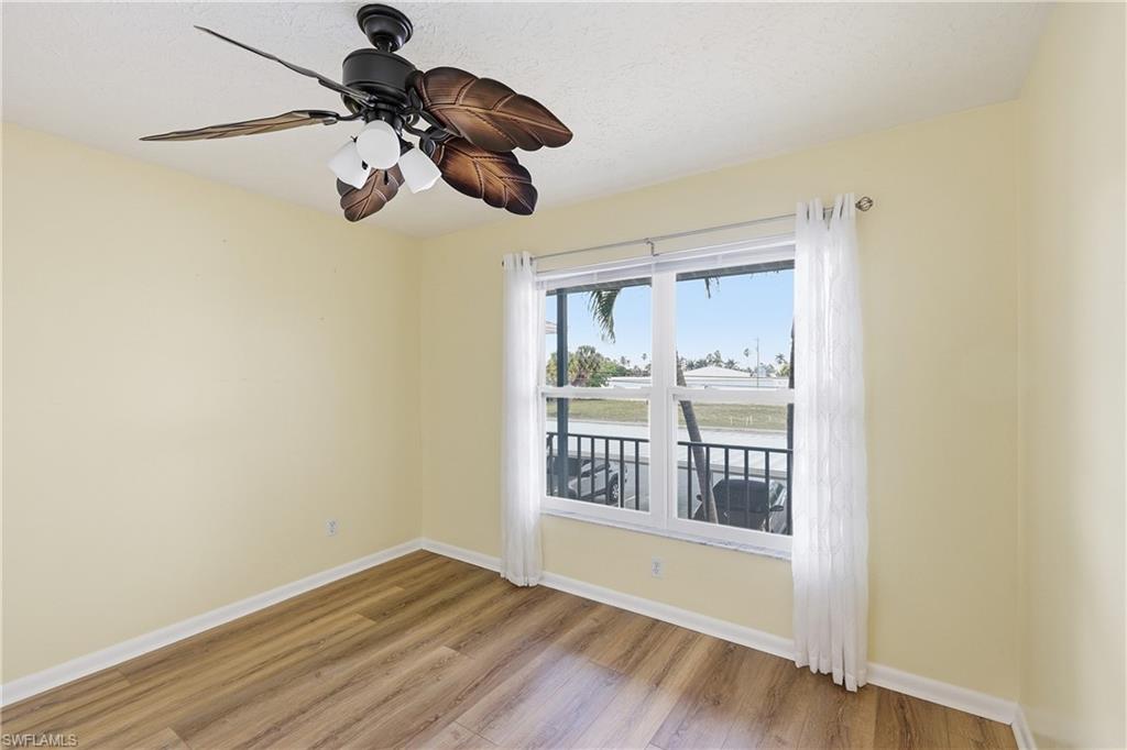 Guest bedroom with view across the street of burrowing owl nests via new impact resistant windows. New luxury vinyl flooring in both bedrooms.