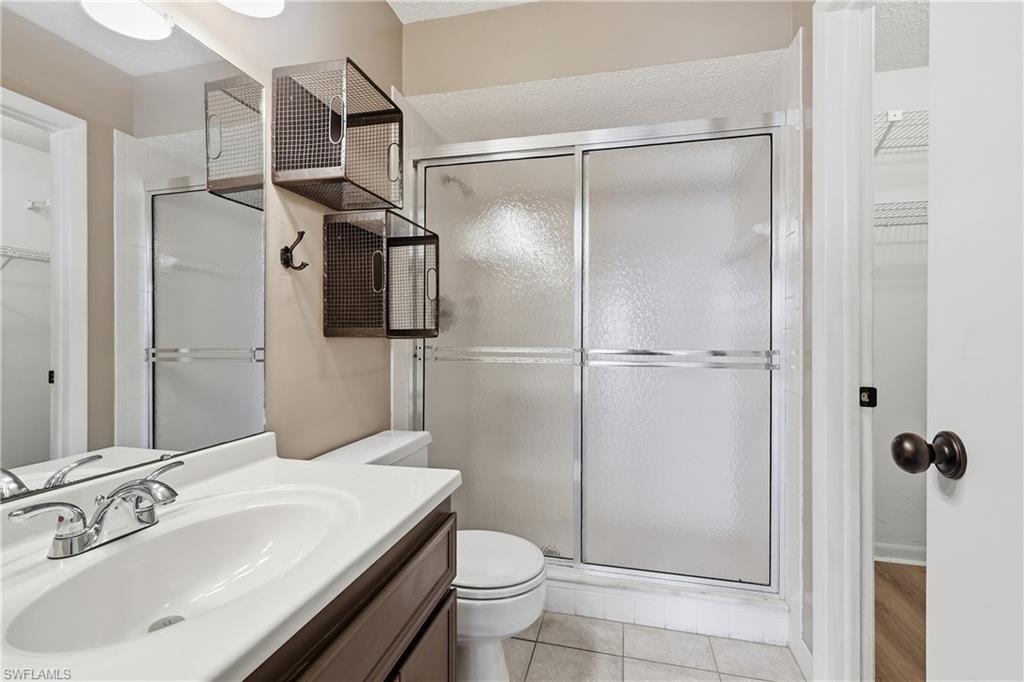 Ensuite bathroom within primary bedroom features a step-in tiled shower.