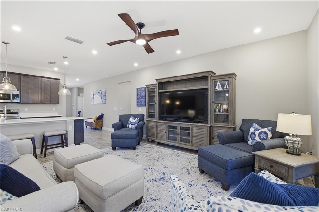 Open-concept living area featuring recessed lighting, a ceiling fan with integrated lighting, and wood-finish flooring